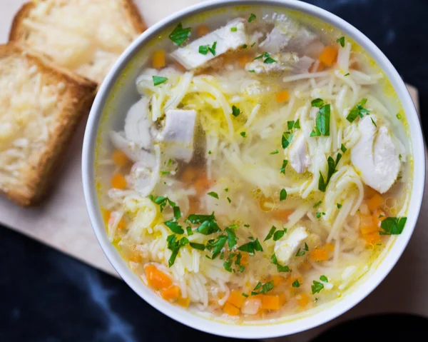 Hühnersuppe mit Nudeln, Karotten und Käsecroutons — Stockfoto