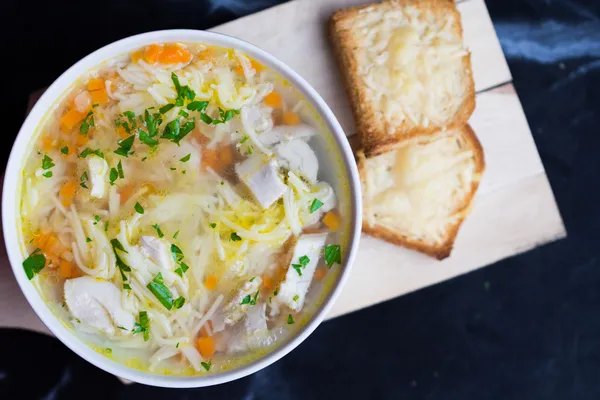 Chicken soup with noodles, carrots and cheese croutons — Stock Photo, Image