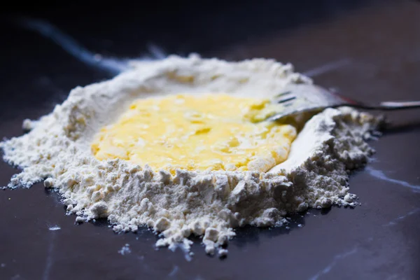 Harina de montaña con profundización y huevo, haciendo pasta casera — Foto de Stock