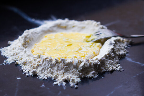 Mountain flour with deepening and egg, making homemade pasta