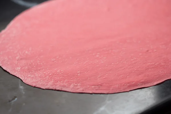 Тонкокатанное розовое тесто для макарон со свекловичным соком — стоковое фото