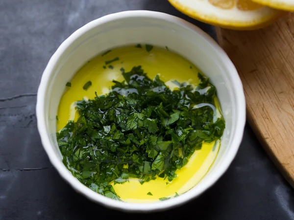 Fresh salad dressing of olive oil, lemon juice and herb parsley — Stock Photo, Image