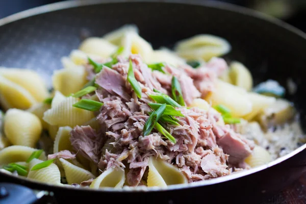 Pasta with tuna, spring onion, sauce and herbs in frying pan — Stock Photo, Image