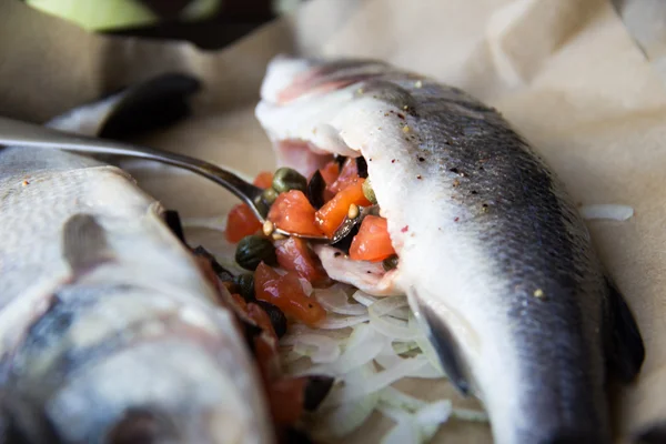 Cooking tasty fish, sea bass,stuffing is stuffed with olives, ca — Stock Photo, Image