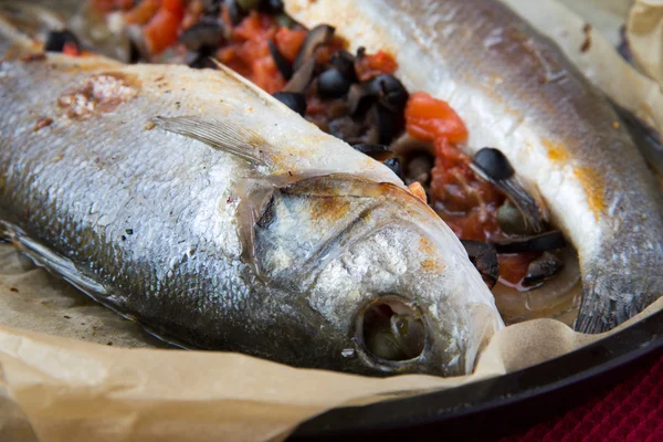 Baked whole white fish, sea bass stuffed with black olives, cape — Stock Photo, Image
