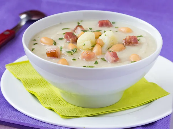 Cream soup with cauliflower, white beans and fried bacon in whit — Stock Photo, Image