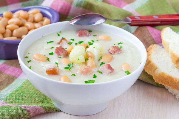 Крем-суп с цветной капустой, белой фасолью и жареным беконом — стоковое фото
