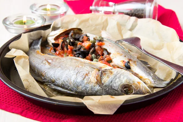 Baked whole white fish, sea bass stuffed with black olives, cape — Stock Image Baked whole white fish, sea bass stuffed with black olives, cape Royalty Free Stock Images