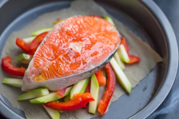 Приготування сирого стейка з червоного рибного лосося на овочах, кабачках, гойдалках — стокове фото