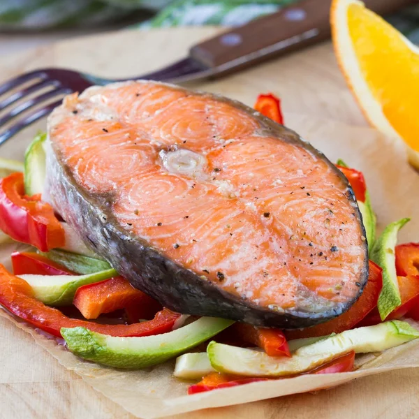 Bife salmão de peixe vermelho em legumes, abobrinha, pimenta doce, ora — Fotografia de Stock