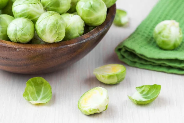 Brotes de Bruselas en un tazón de madera sobre la mesa, sabroso, saludable v — Foto de Stock