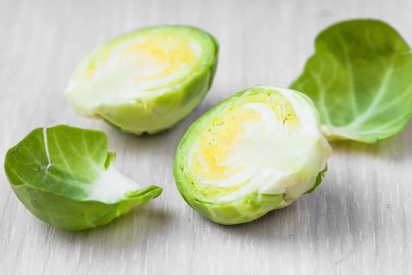 Brotes de Bruselas en un tazón de madera sobre la mesa, sabroso, saludable v — Foto de Stock