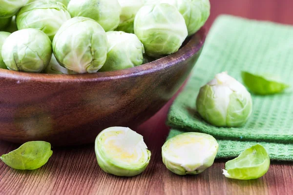 Rosenkohl sprießt in einer hölzernen Schüssel auf dem Tisch, lecker, gesund — Stockfoto