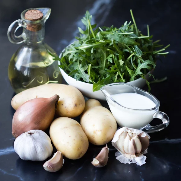 Ingredients for cooking potato soup with garlic, rukola, onions, — Stock Photo, Image