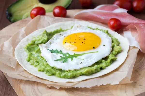 Desayuno con huevo frito y salsa de aguacate sobre harina asada t —  Fotos de Stock