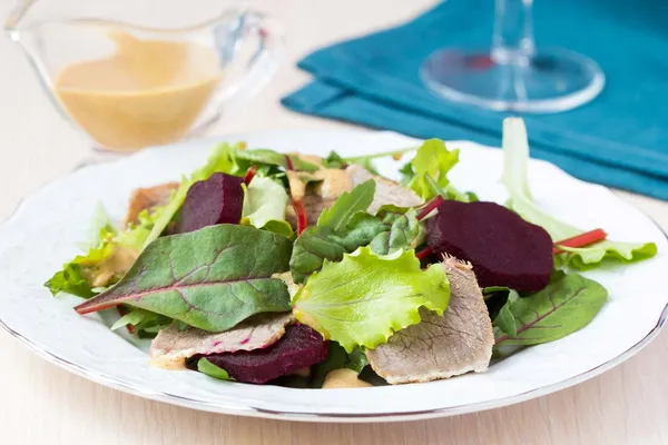 Свежий салат с листьями салата, вареной говядиной, свеклой, горчичным сауком — стоковое фото