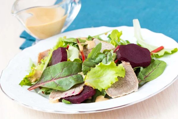 Verse salade met sla bladeren, gekookte rundvlees, suikerbieten, mosterd sauc — Stockfoto