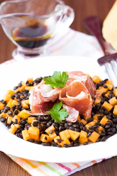 Salát s černými čočka, šunka Jamón, dýně, sojová omáčka, chutné — Stock fotografie