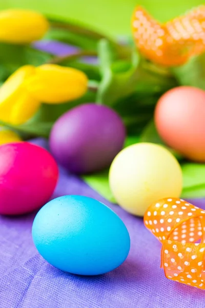 Colorful easter eggs with yellow tulips flowers — Stock Photo, Image
