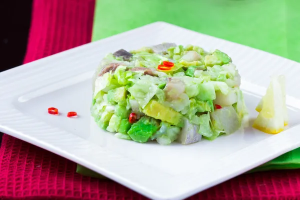 Элегантный салат татар с сельдью, авокадо, салатом, рестораном — стоковое фото