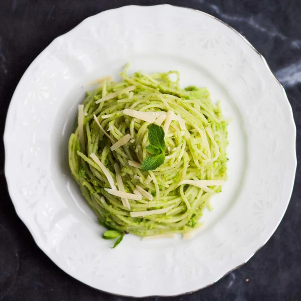 Włoski zielony makaron spaghetti z pesto, zielony groszek, mięta, pista — Zdjęcie stockowe