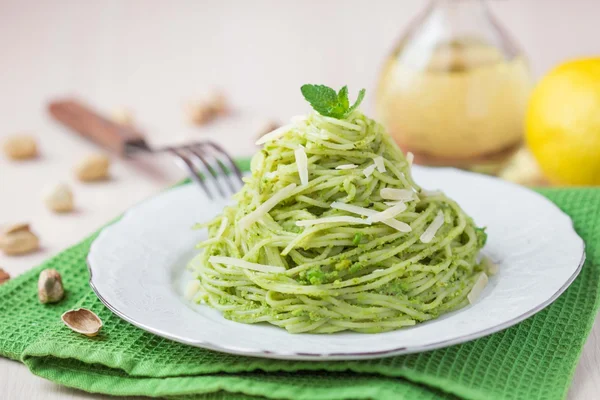 Włoski zielony makaron spaghetti z pesto, zielony groszek, mięta, pista — Zdjęcie stockowe