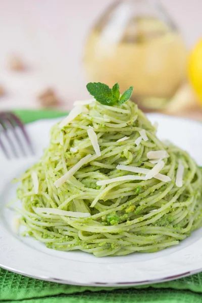 Włoski zielony makaron spaghetti z pesto, zielony groszek, mięta, pista — Zdjęcie stockowe