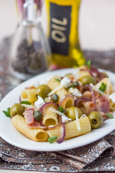 Rigatoni pasta met spek, rode ui, groene olijven, fetakaas, — Stockfoto