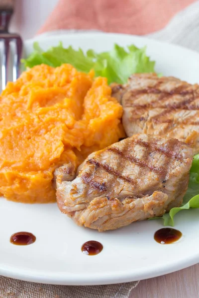 Pork steak fried on grill with mashed sweet potatoes, tasty — Stock Photo, Image