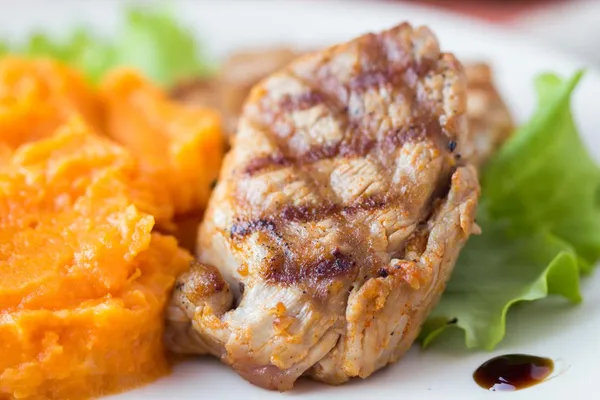 Pork steak fried on grill with mashed sweet potatoes, tasty — Stock Photo, Image