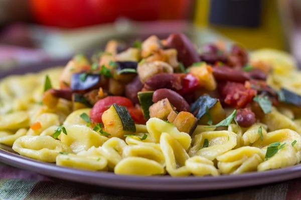 Italiensk pasta orecchiette med gryta grönsaker och bönor, del — Stockfoto