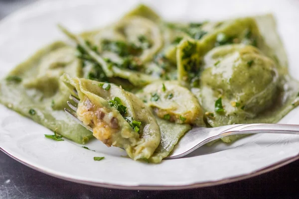 Pâtes de ravioli à base de pâte verte avec farce aux champignons, huile, pars — Photo