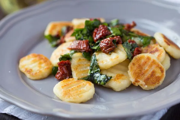 Fried potato gnocchi with sauce of dried tomatoes, spinach, Ital — Stock Photo, Image