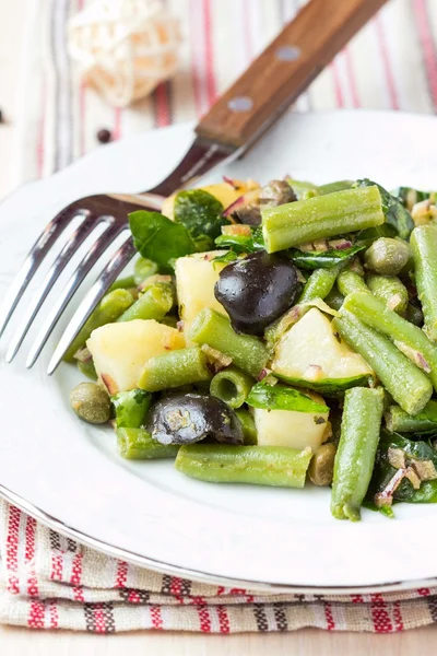 Картофельный салат с зеленой фасолью, оливками, каперсами, луком, вкусный — стоковое фото