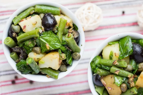 Aardappelsalade met olijven, kappertjes, groene bonen, uien, heerlijke — Stockfoto