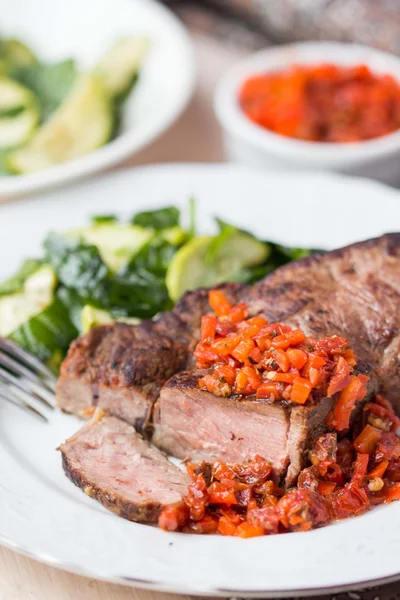 Bistecca di manzo alla griglia con salsa di pomodori secchi, peperoni rossi — Foto Stock