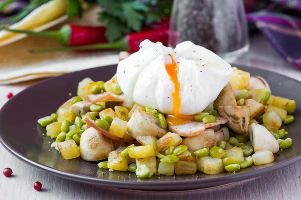 Hot salad with potatoes, ham, peas, mushrooms, poached egg — Stock Photo, Image