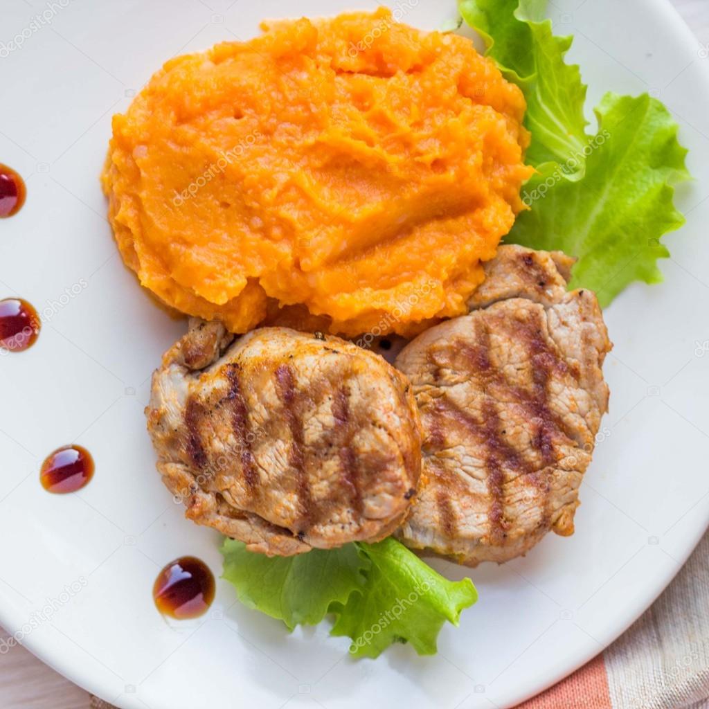 Pork steak fried on grill with mashed sweet potatoes, tasty