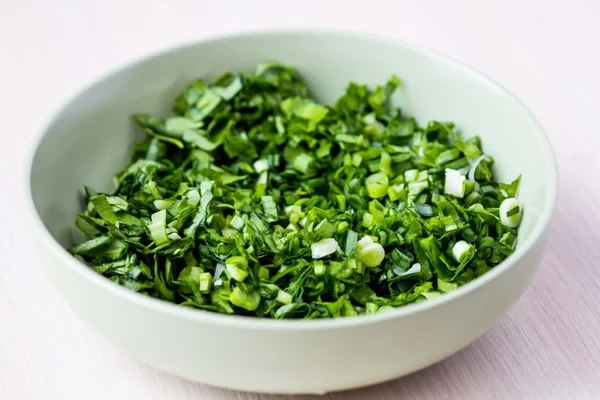 Green chopped herbs in bowl, parsley, ramson, spring onion, summ — Stockfoto