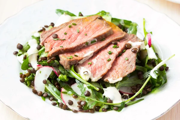 Salad with grilled beef steak, black lentils, rocket, radish, cu — Stock Photo, Image