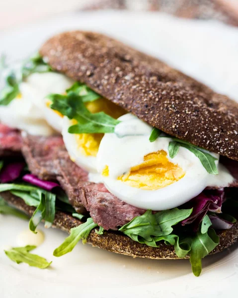 Sandwich with grilled beef steak, eggs, arugula, rye bread — Stock Photo, Image