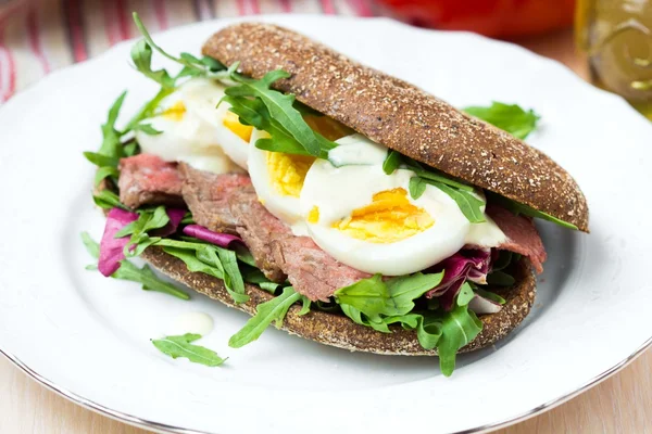 Sandwich con bistec a la parrilla, huevos, rúcula, pan de centeno —  Fotos de Stock