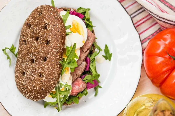 Sandwich con bistec a la parrilla, huevos, rúcula, pan de centeno —  Fotos de Stock