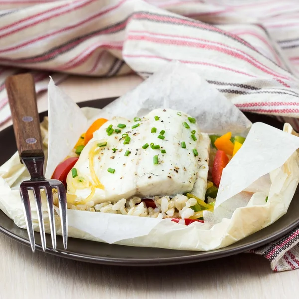 Filete de pescado blanco cocido en papel, pergamino con arroz, pimienta — Foto de Stock