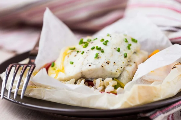 Filete de pescado blanco cocido en papel, pergamino con arroz, pimienta — Foto de Stock