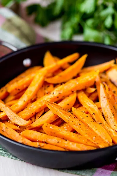 Patates douces, batata, tranchées, frites dans une poêle avec des épices, herbes — Photo