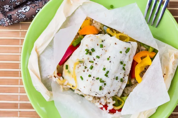 White fish fillet baked in paper, parchment with rice, pepper — Stock Image White fish fillet baked in paper, parchment with rice, pepper Stock Image
