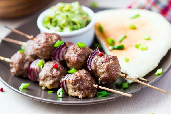 Kebab de carne, bolas de ternera en pincho con cebolla, salsa guacamole —  Fotos de Stock