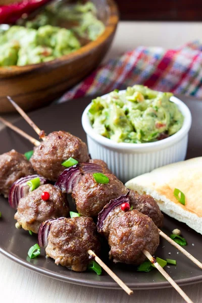 Meat kebab, beef balls on skewer with onions, sauce guacamole — Stock Photo, Image