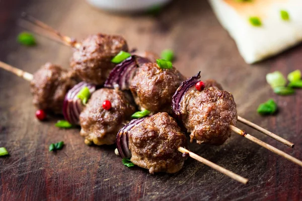 Meat kebab, beef balls on skewer with onions, sauce guacamole — Stock Photo, Image